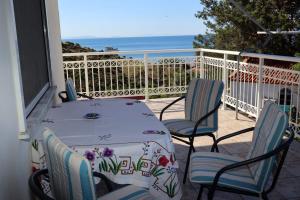 a table and chairs on a balcony with the ocean at Sea view apartment in Plomari