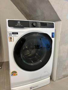 a white washing machine sitting in a room at 2 Bed & 2 Bath Suite, 5th floor in Ban Bang Toei (1)