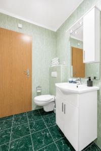 a bathroom with a white sink and a toilet at Galeb Bed and Breakfast in Baćina +50 photos