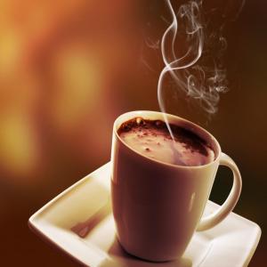 a cup of coffee on a plate with smoke at Mauya Executive Lodge in Dar es Salaam