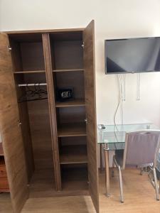 a bookcase next to a desk with a television at Zátonyi Csárda Panzió in Dunasziget