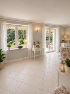 a living room with white tile floors and windows at Prestige Garden Villa - Cracow in Krakow
