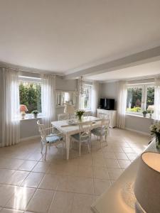 a kitchen and dining room with a white table and chairs at Prestige Garden Villa - Cracow in Krakow