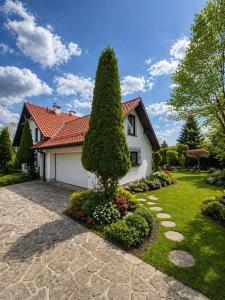 a house with a tree in the front yard at Prestige Garden Villa - Cracow in Krakow
