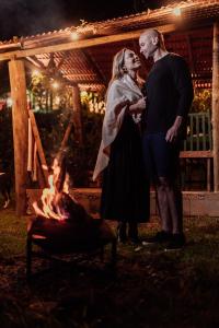 a man and a woman standing in front of a fire at Pousada Sitio e Poesia in Teresópolis +136 photos