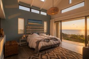 a bedroom with a bed with a view of the ocean at Peninsula Villa - Romansbaai in Gansbaai