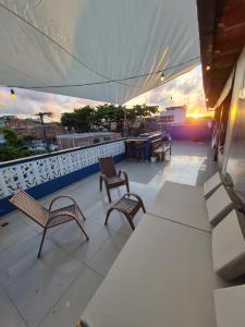 a balcony with two chairs and a table on a building at Praieira Pousada in Itacaré