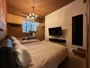 a bedroom with a large bed and a television at 上水民宿 in Chiayi City