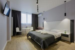 a bedroom with a bed and a table and a television at Вікторі Апарт in Kyiv