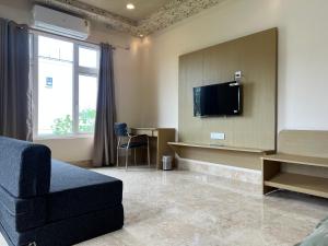 a living room with a couch and a flat screen tv at Kaizen Living in Guwahati