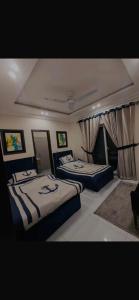 two beds sitting in a room with curtains at Global properties in Faisalabad