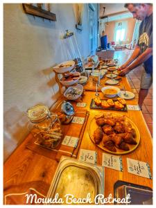 a long wooden table with food on it at Mounda Beach Retreat in Skala