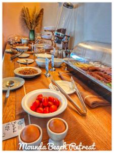 a table with plates of food and bowls of food at Mounda Beach Retreat in Skala