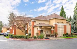 a house with a car parked in a parking lot at Extended Stay America Suites - Portland - Tigard in Tigard