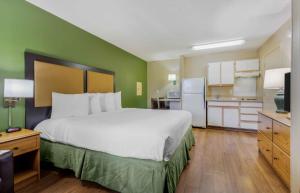 a bedroom with a large bed and a kitchen at Extended Stay America Suites - Portland - Tigard in Tigard