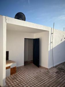 a garage with a black door in a white building at Catalan in Martil
