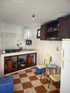 a kitchen with a checkered floor and a counter and chairs at Catalan in Martil