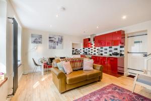 a living room with a couch and a kitchen with red cabinets at 2 Bed in Cromer oc-2309 in Cromer