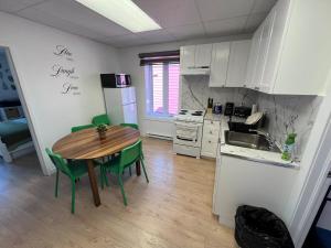 a kitchen with a wooden table and a kitchen with white cabinets at Appartement 2 - Est in Rimouski