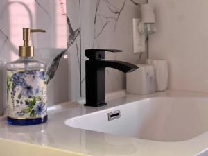 a sink with a soap dispenser and a bottle of water at Appartement 2 - Est in Rimouski +39 photos