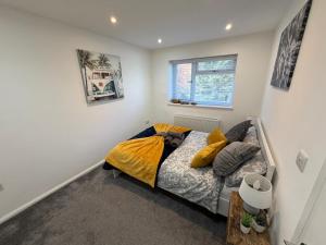 a bedroom with a bed with yellow and gray pillows at Stylish Charming London Flat Ruislip -Free Parking in Ruislip