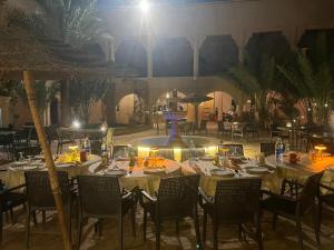 a group of tables and chairs in a restaurant at Kasbah Zitoune in Ouarzazate