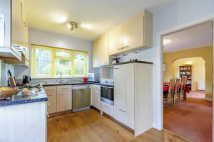 a kitchen with white cabinets and a dining room at 4 Bed in Ilkley oc-ds168 in Ilkley