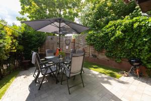a table and chairs with an umbrella on a patio at Sári Apartman in Balatonalmádi +4 photos