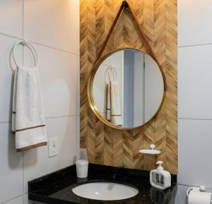 a bathroom with a mirror and a sink at Apto Tropical - Enseadas dos Corais in Cabo de Santo Agostinho