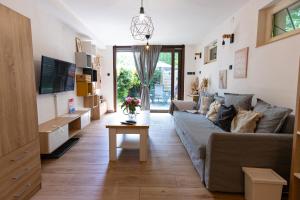 a living room with a couch and a table at Sári Apartman in Balatonalmádi