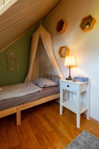 a bedroom with a bed and a table with a lamp at Sári Apartman in Balatonalmádi