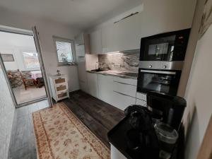 a small kitchen with a stove and a microwave at Apartman Leo in Mariánské Lázně