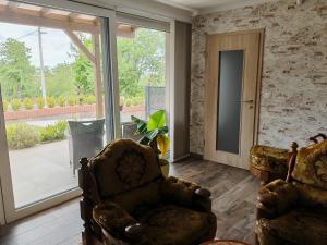 a living room with two chairs and a sliding glass door at Apartman Leo in Mariánské Lázně