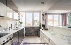 a kitchen with white counters and a large window at Quarto confortável in Amadora +10 photos