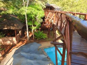 a wooden deck with a swimming pool next to a house at Bona Ngwenya Lodge & Safaris in Marloth Park