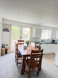 a kitchen and dining room with a wooden table and chairs at Stylish Charming London Flat Ruislip -Free Parking in Ruislip