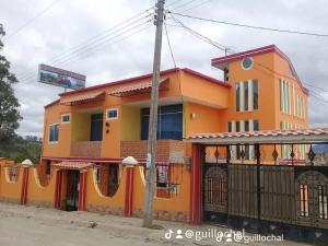an orange and yellow building on the side of a street at Hostal Juyanis in Otavalo
