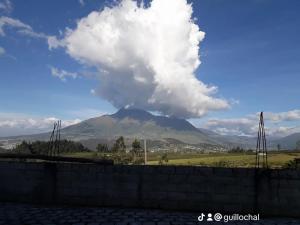 a mountain in the distance with a cloud above it at Hostal Juyanis in Otavalo