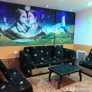 a living room with a couch and a painting at Hostal Juyanis in Otavalo