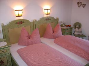 a bedroom with two beds with pink pillows at Haus Egger in Reit im Winkl