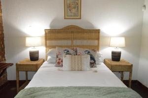 a bedroom with a large bed with two lamps at Bona Ngwenya Lodge & Safaris in Marloth Park