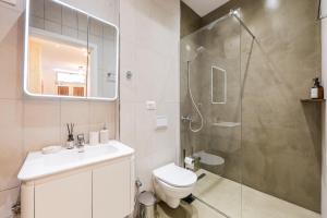 a bathroom with a shower and a toilet and a sink at NooN Properties Santorini by PikHost in Palasë +68 photos