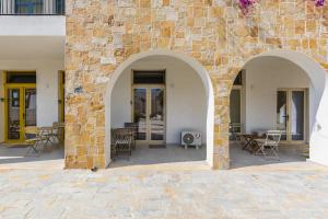 a brick wall with two arches on a patio at NooN Properties Santorini by PikHost in Palasë