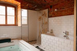 a white bathroom with a tub and a window at Folwark Wielka Wieś in Główczyce +71 photos