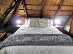 a bedroom with a bed with two lamps on both sides at Bona Ngwenya Lodge & Safaris in Marloth Park