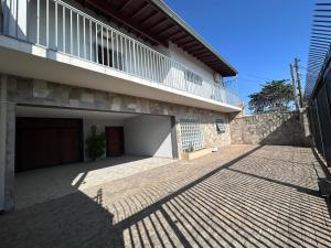 a building with a garage and a balcony on top at Hospedaria Campinas in Campinas