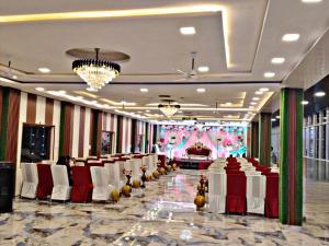 a banquet hall with red and white tables and chairs at SK Palace in Rāe Bareli