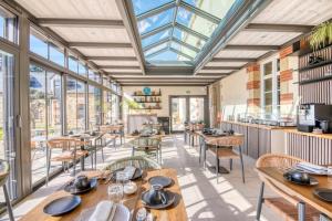 a restaurant with tables and chairs and windows at Le Manoir de Kerbot in Sarzeau +14 photos