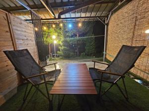 two chairs and a wooden table on a patio at Danyang Kotdle Moolgam Chatki Pension in Danyang