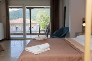 a hotel room with a bed with towels on it at Studios Denis in Stavros +149 photos
